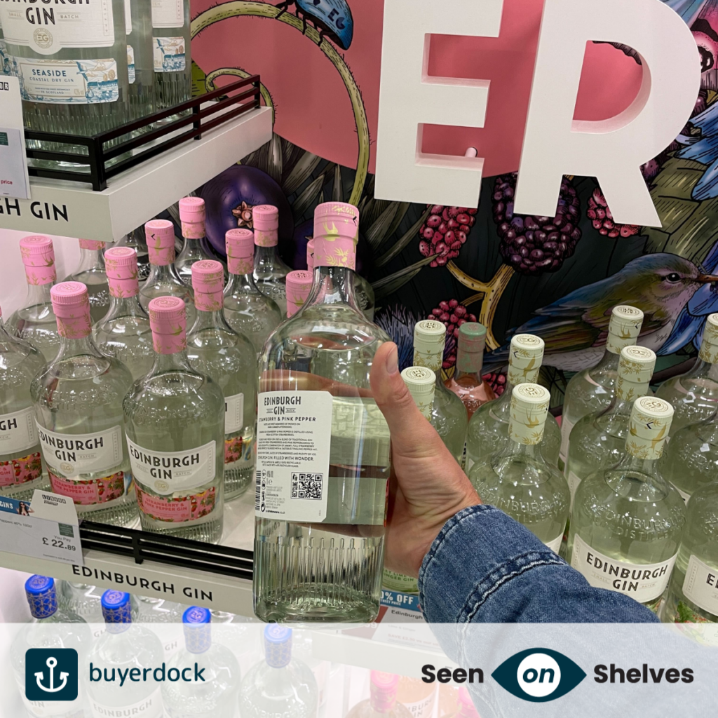 a consumer picking up a bottle of Edinburgh gin showing a buyerdock iQRcode ready to scan at the till